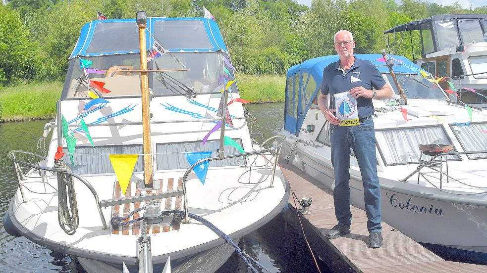 BV Wiesens Vorsitzender Gerold Ley neben seinem Boot mit der Fahne in der Hand, die die Durchfahrt durch die Schleusen ohne Bezahlung ermöglicht. Foto: Gerd-Arnold Ubben
