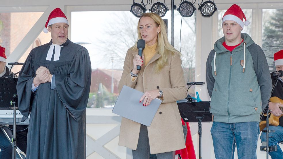 Pastor Carsten Greite gemeinsam mit Osteels Bürgermeisterin Ida Bienhoff-Topp und Achim Abels vom Bürgerverein „Osteel maakt wat“ bei der Eröffnung des Adventsmarkts 2018. Foto: Folkert Bents