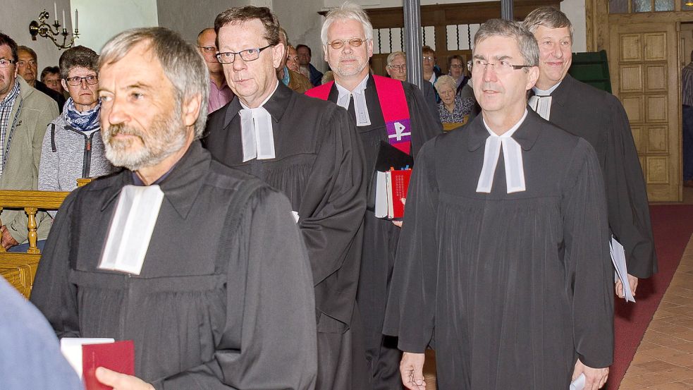 Eskortiert von seinen Kollegen zog Pastor Carsten Greite (ganz rechts) im September 2017 zu seiner Amtseinführung in die Osteeler Warnfriedkirche ein. Mit ihm gingen (von links): Eskil Wohlberg, Peter Riesebeck, Superintendent Dr. Helmut Kirschstein und Norbert Masslich. Foto: Folkert Bents