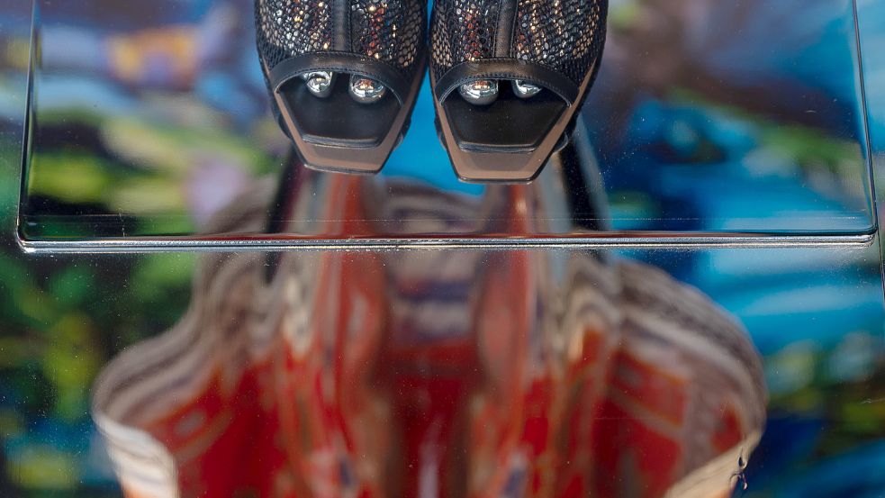 Eine Schaufensterpuppe mit einem Kleid spiegelt sich im Boden. Das heimliche Fotografieren unter den Rock oder in den Ausschnitt ist eine Straftat. Symbolfoto: DPA