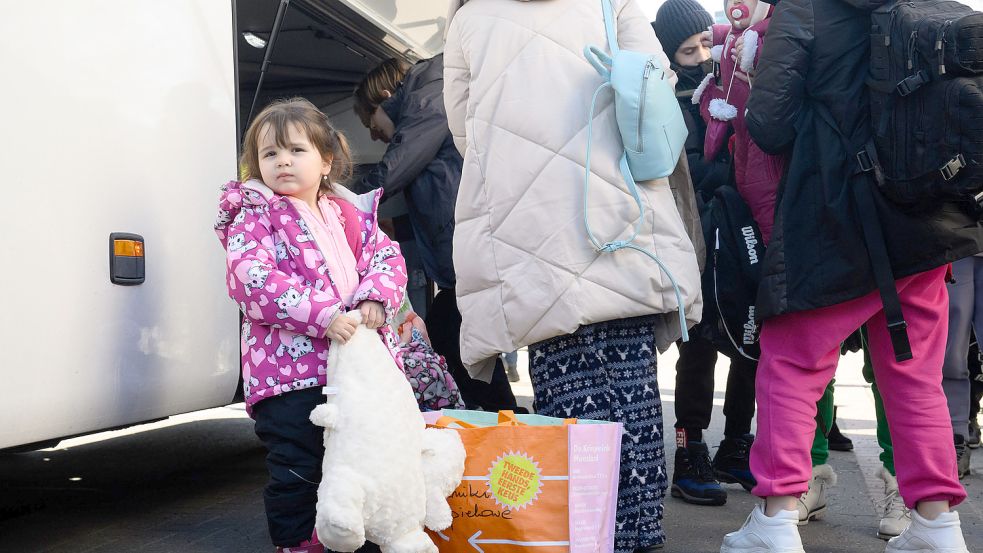 Ukrainische Geflüchtete stehen an einem Bus. Foto: DPA