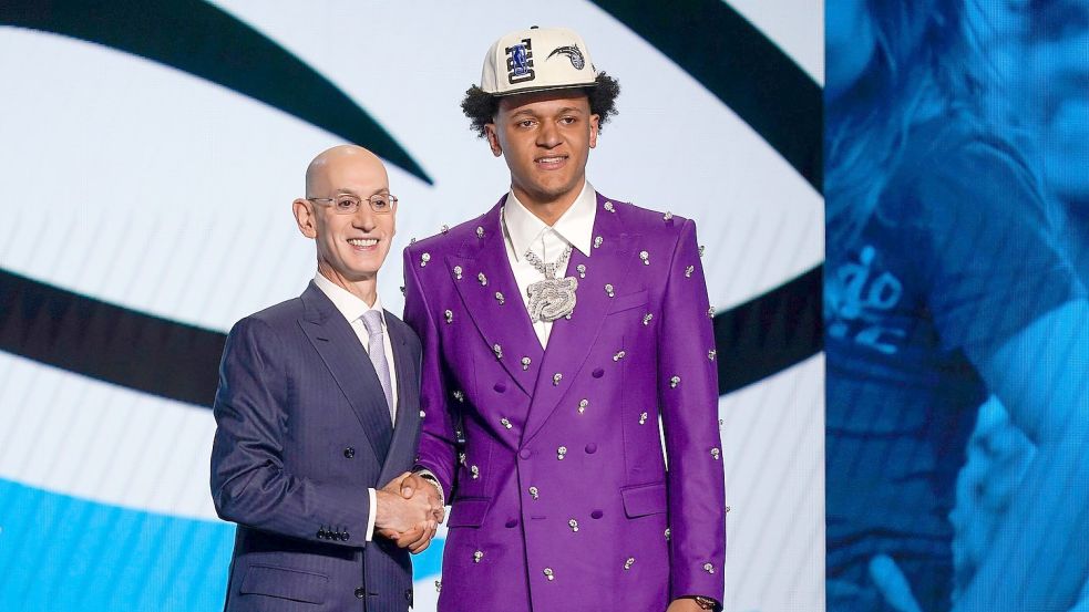 Paolo Banchero (r) steht neben NBA-Boss Adam Silver, nachdem er von den Orlando Magic als Nummer eins im Draft ausgewählt wurde. Foto: John Minchillo/AP/dpa