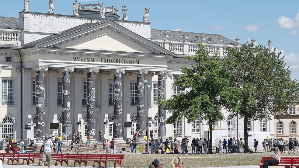 Besucher stehen vor dem Museum Fridericianum auf der documenta fifteen. Foto: Swen Pförtner/dpa Foto: Swen Pförtner