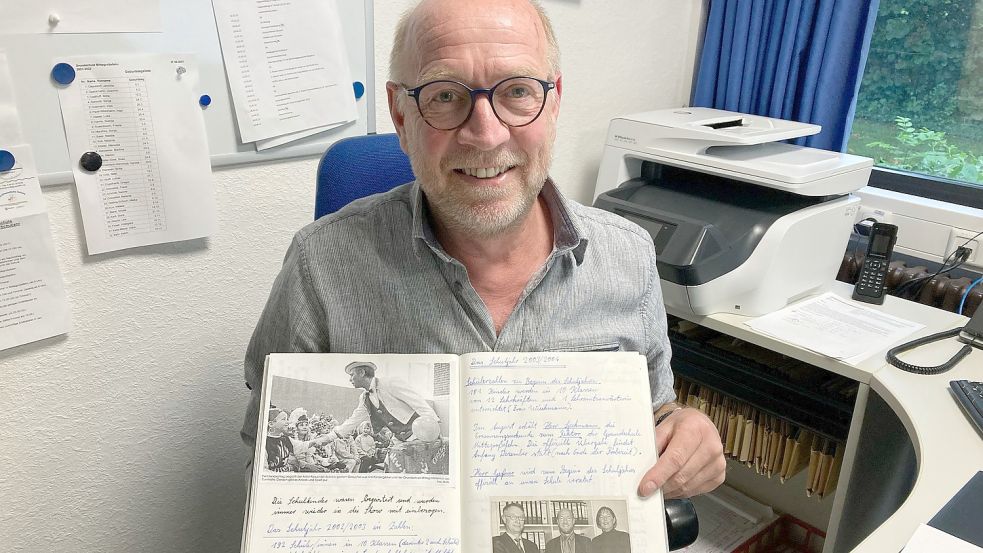 Joachim Speckmann zeigt einen alten Zeitungsartikel über seine Ernennung als Schulleiter der Grundschule Mittegroßefehn. Foto: Imke Cirksena