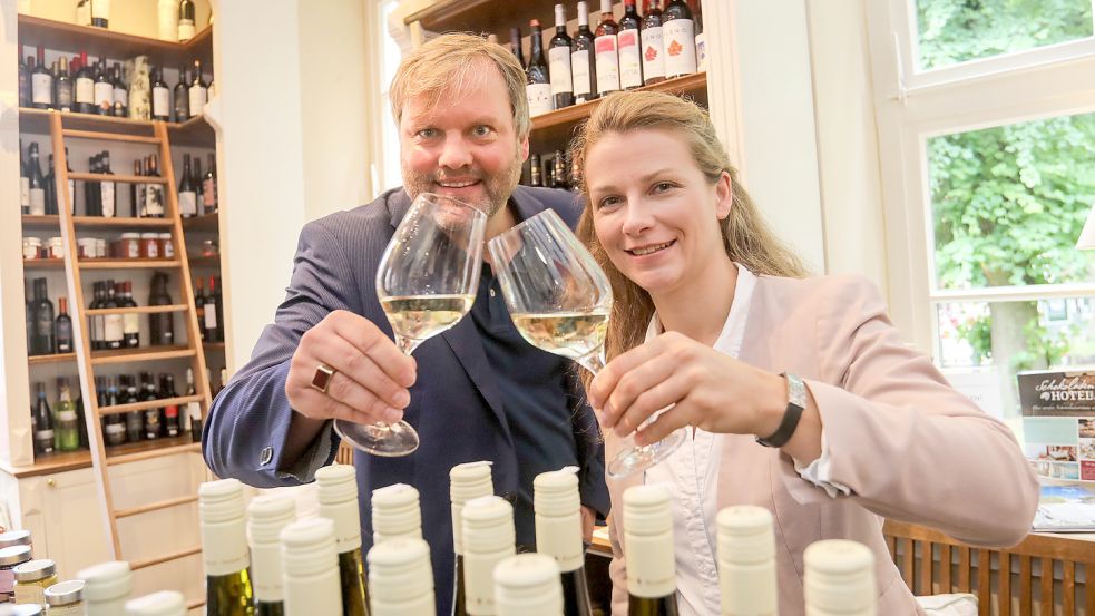 Udo Hippen, Vorsitzender des Kaufmännischen Vereins, und Sandra Pfeiffer-Fecht vom Auricher Stadtmarketing stoßen auf das Gelingen des Weinfestes an. Foto: Romuald Banik