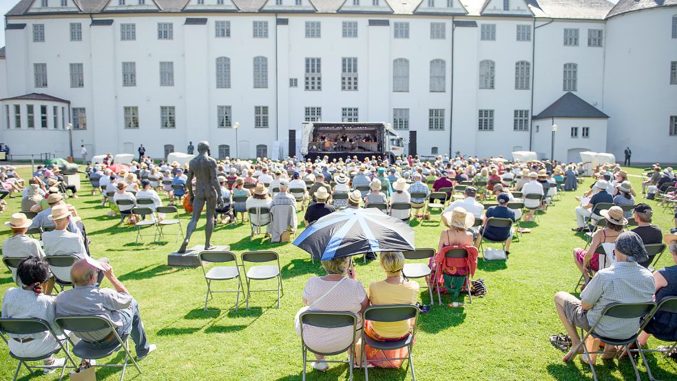 Open Air geht immer: Besucher sitzen während eines Konzertes im Rahmen des Schleswig-Holstein Musik Festivals (SHMF) 2021 vor dem Schloss Gottorf in Schleswig. Foto: dpa