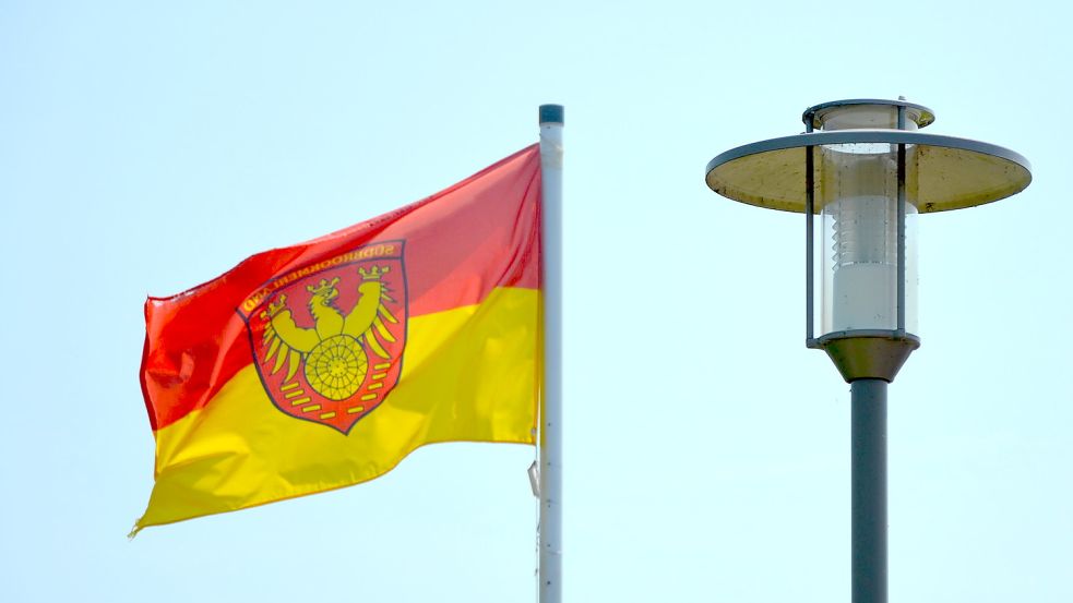 Die Flagge der Gemeinde Südbrookmerland weht am Großen Meer neben einer Laterne. Fotos: Franziska Otto