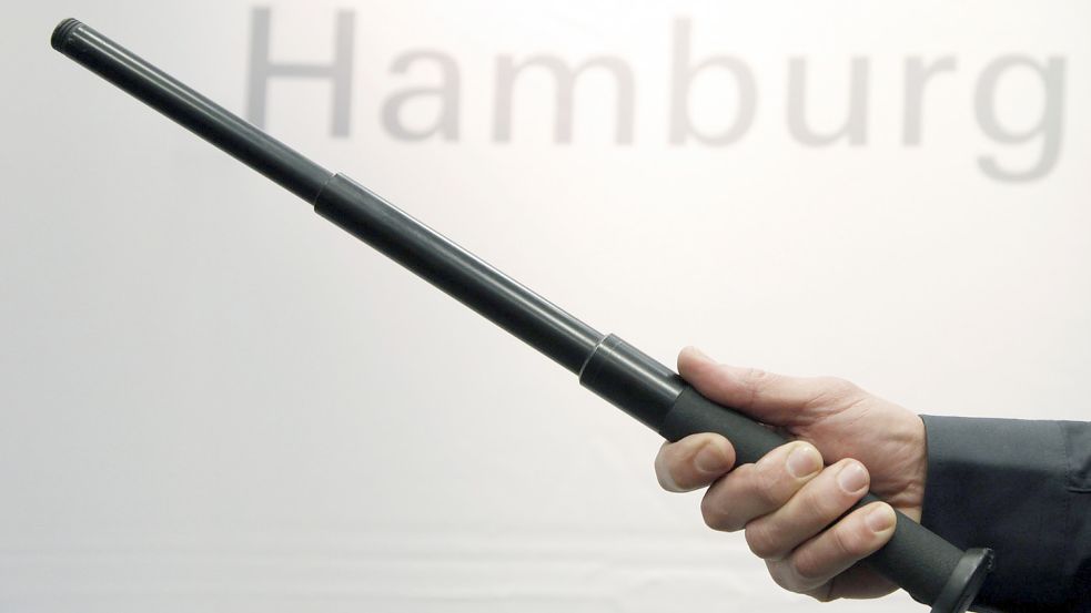 Ein Polizist präsentiert in Hamburg einen Teleskopschlagstock. Foto: DPA