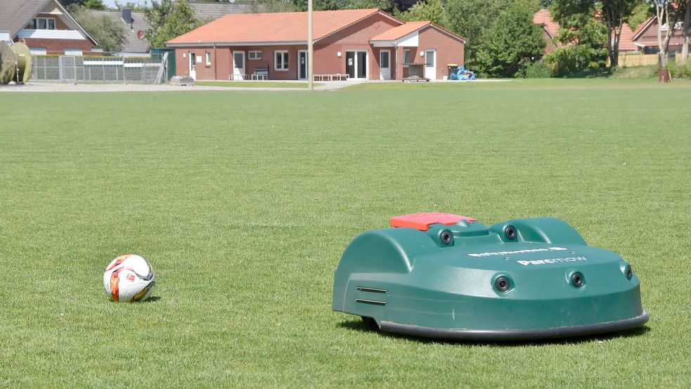 Ganz schön groß im Vergleich zu einem Fußball: Der Mähroboter auf dem Leezdorfer Sportplatz hat eine Schnittbreite von 63 Zentimetern. Foto: Thomas Dirks