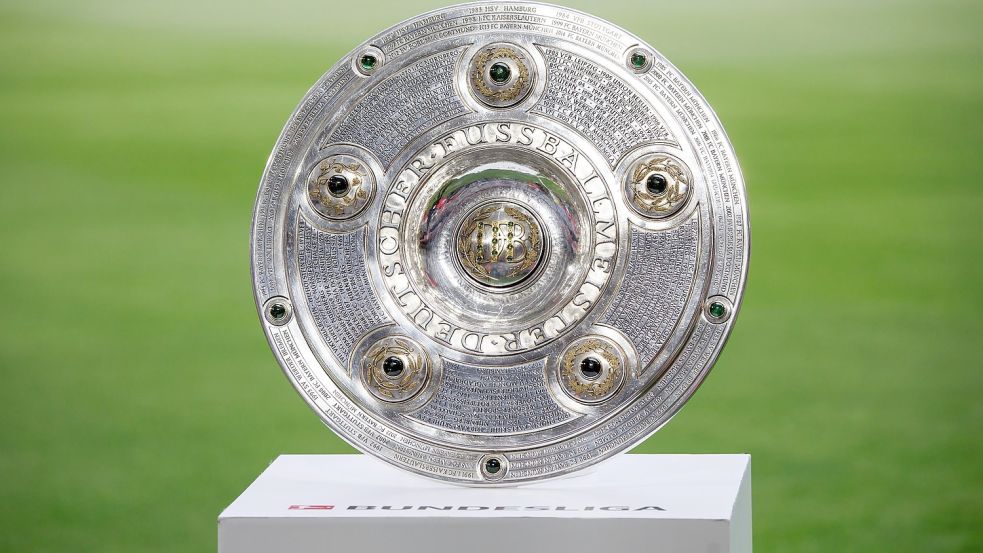 Die Meisterschale ist vor Spielbeginn auf einem Podest zu sehen. Foto: Matthias Balk/dpa