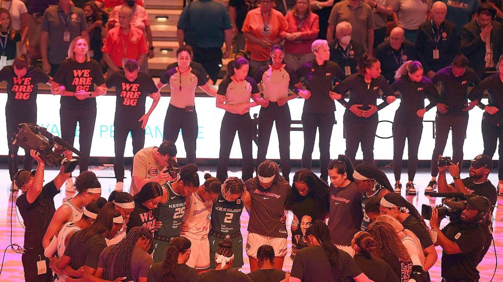 Die Teams der Connecticut Sun und der Phoenix Mercury verschränken vor einem Spiel der WNBA die Arme zu Ehren von Brittney Griner. Foto: Sarah Gordon/The Day/AP/dpa