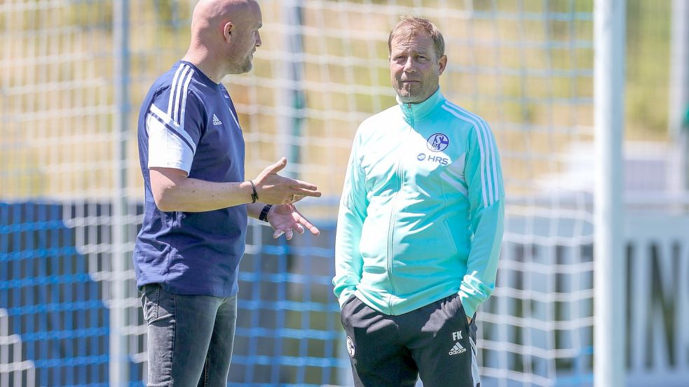 Schalkes Sportdirektor Rouven Schröder (l) im Gespräch mit Cheftrainer Frank Kramer. Foto: Tim Rehbein/dpa