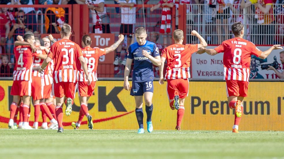 Die Mannschaft von Union jubelt nach dem 1:0 Treffer durch Sheraldo Becker - Herthas Jonjoe Kenny lässt den Kopf hängen. Foto: Andreas Gora/dpa