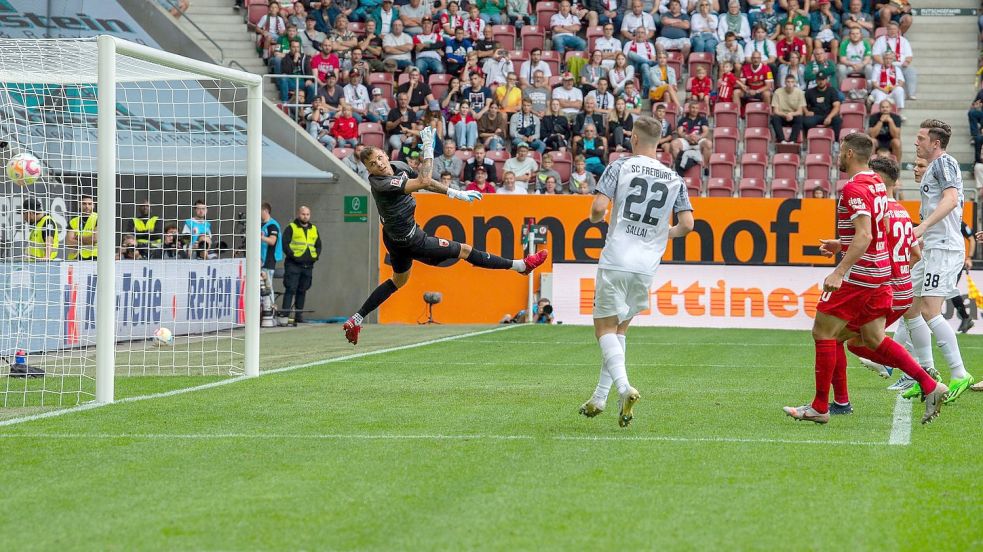 Augsburgs Torwart Rafal Gikiewicz (l) kann dem Ball beim 0:2 nur noch hinterherschauen. Foto: Stefan Puchner/dpa