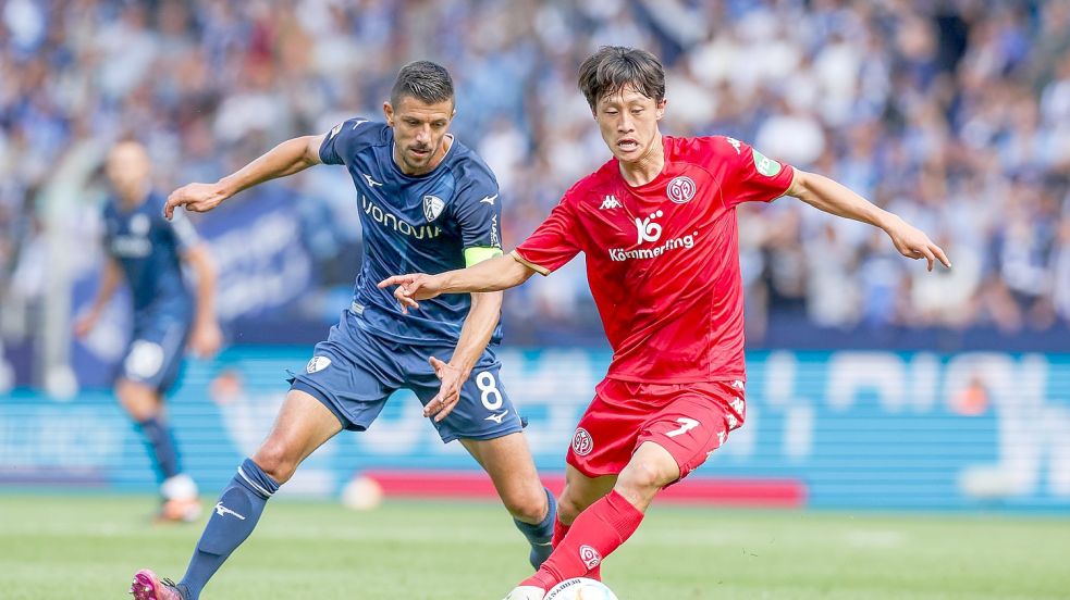 Bochums Anthony Losilla (l) kämpft mit dem Mainzer Jae-Sung Lee um den Ball. Foto: Tim Rehbein/dpa