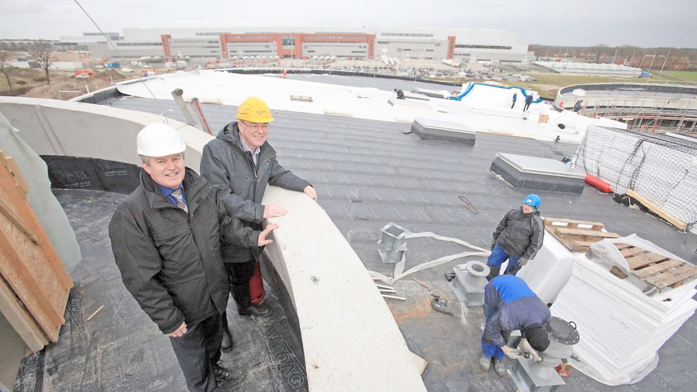Bild aus dem Jahr 2014: Aurichs Erster Stadtrat Hardwig Kuiper (vorne) und der damalige Vorsitzende der ABH, Hinrich Wilts, auf dem Turm des Energie-Erlebnis-Zentrums. Handwerker arbeiten daran, eine Photovoltaikanlage anzubringen. Foto: Romuald Banik