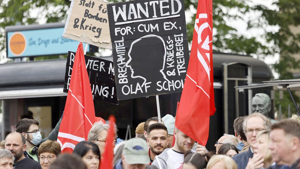 Ein Demonstrant gegen Kanzler Olaf Scholz hält ein Plakat mit den Worten Wanted for: Cum Ex in die Höhe auf der DGB-Veranstaltung in Düsseldorf. Foto: imago-images/Panama Pictures