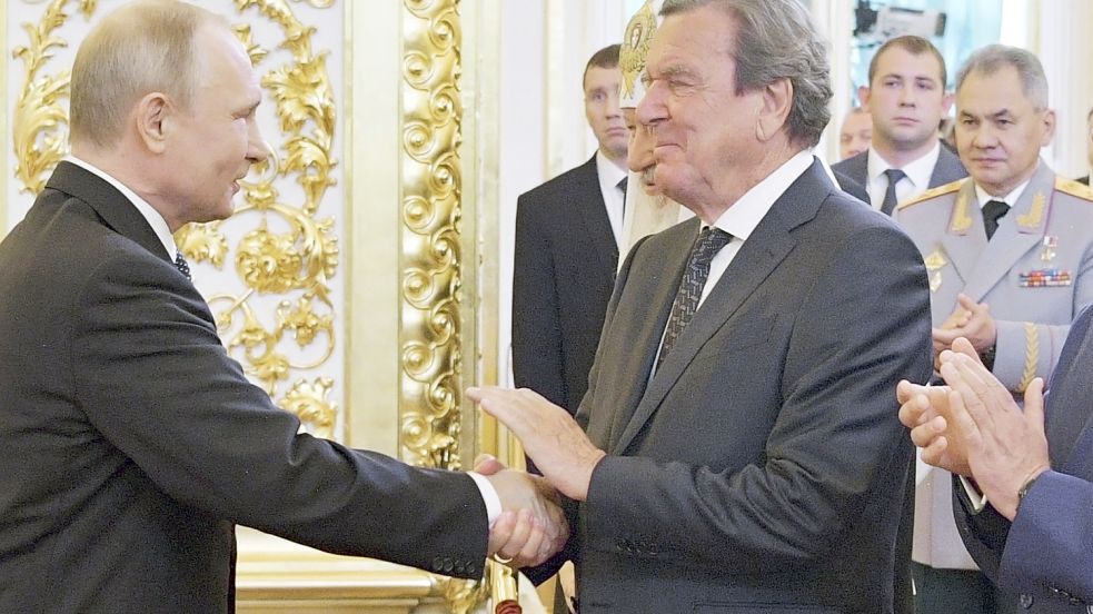 Schröder besucht Putin im Kreml - im Hintergrund der russische Verteidigungsminister Foto: Alexei Druzhinin/dpa