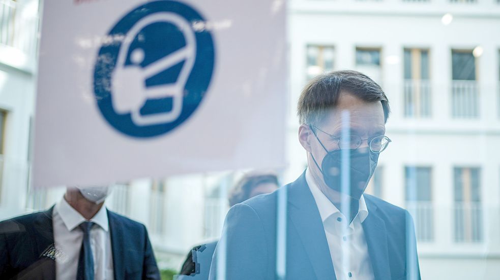 Karl Lauterbach (SPD), Bundesminister für Gesundheit, geht an einem Hinweisschild auf die Maskenpflicht vorbei. Foto: DPA