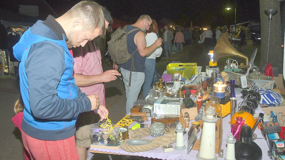 Mit Taschenlampen stöberten Besucher über den Nachtflohmarkt, einem der Höhepunkte des Simonswolder Flohmarktes. Foto: Gerd-Arnold Ubben