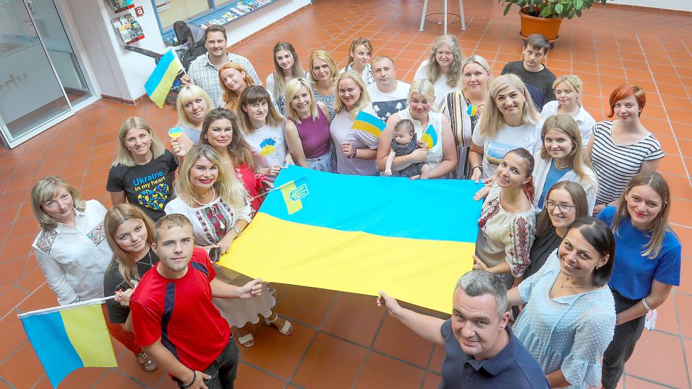 Aus der Ukraine geflüchtete Menschen halten am Unabhängigkeitstag ihres Landes eine Flagge. Foto: Romuald Banik