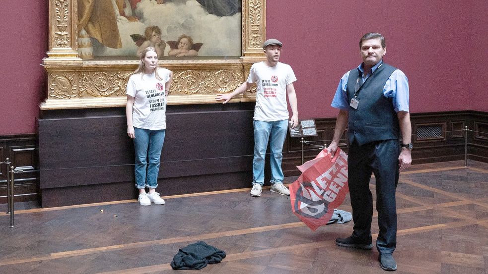 Soviel Zeit muss sein: Die Kunstaktionen der „Letzten Generation“ sind schnell vorbei. Aber dank der „Sixtinischen Madonna“ als Ziel der Aktivisten ist ihnen maximale Aufmerksamkeit garantiert. Foto: Sebastian Kahnert/dpa
