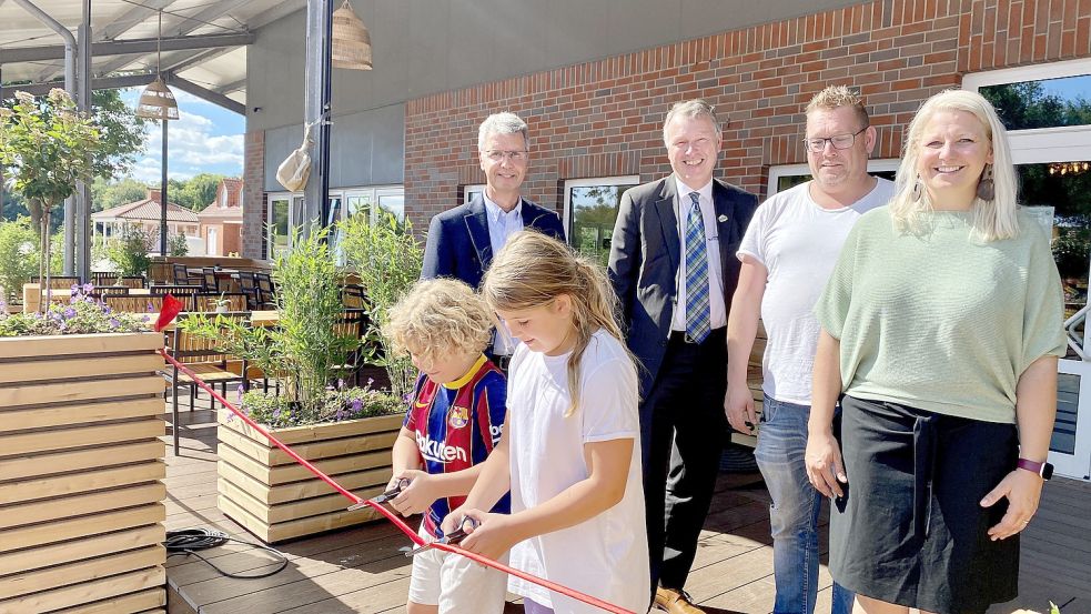 Ulrich Kubatschek (von links), Geschäftsführer der Ihlower Entwicklungs- und Dienstleistungsgesellschaft, und der Ihlower Bürgermeister Arno Ulrichs übergaben die neue Terrasse am Ihler Meer an die Gastronomen Markus und Christiane Kruse mit den Kindern Theo und Marie. Foto: Gemeinde Ihlow