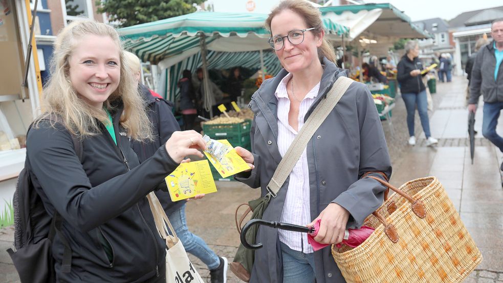 Grietje Kammler übergibt die plattdeutsche Einkaufsliste an Maike Gilgenast aus Norden. Foto: Romuald Banik