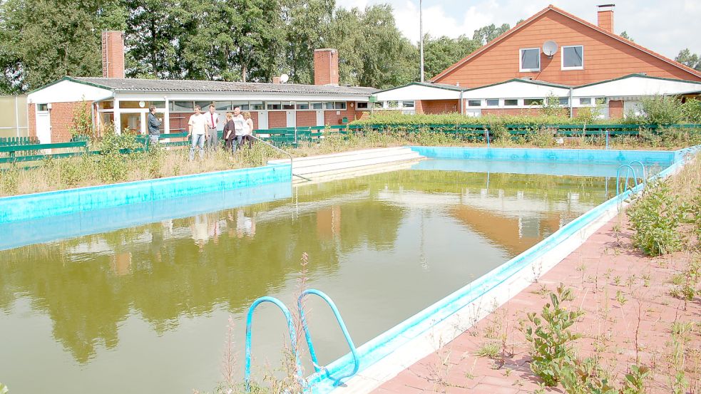 So sah es dort auf dem Gelände des ehemaligen Simonswolder Schwimmbades vor 15 Jahren aus. Der damalige Simonswolder Ortsbürgermeister und heutige Bürgermeister der Gemeinde Ihlow, Arno Ulrichs, im Gespräch mit der Vorsitzenden des Sand- und Waterwerks, Erika Bongers, und ihren Mitstreitern. Foto: Gerd-Arnold Ubben