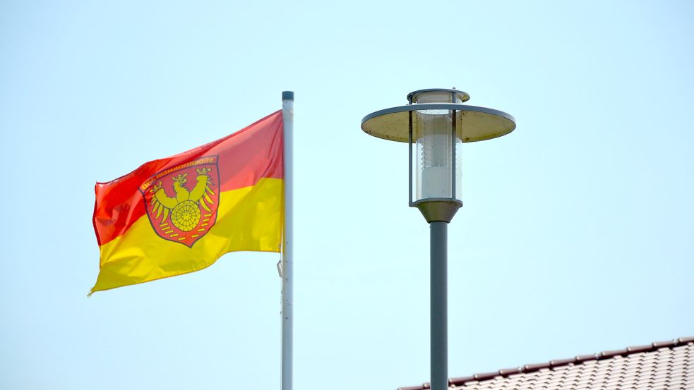 Die Flagge der Gemeinde Südbrookmerland weht neben einer Laterne. Foto: Franziska Otto
