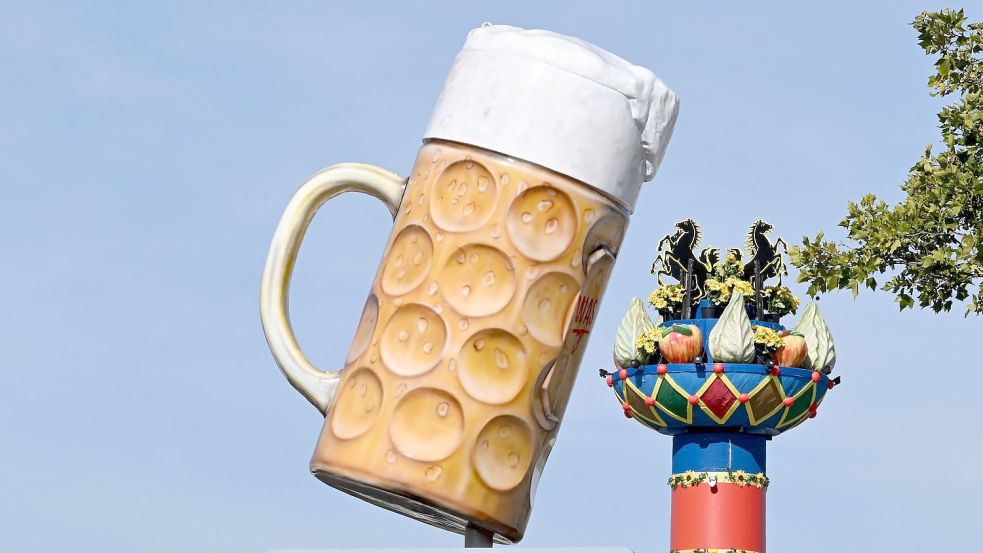 Ein riesiger Bierkrug steht am Eingang auf dem Festgelände Cannstatter Wasen, im Hintergrund steht die Fruchtsäule. Foto: Bernd Weißbrod/dpa