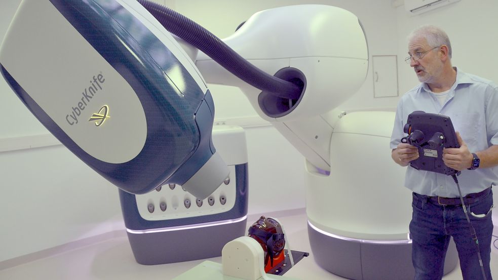 Medizinphysiker Hans-Willi Breyer demonstrierte, wie der Strahlen-Roboter um den Kopf eines Patienten fährt. Foto: Aiko Recke
