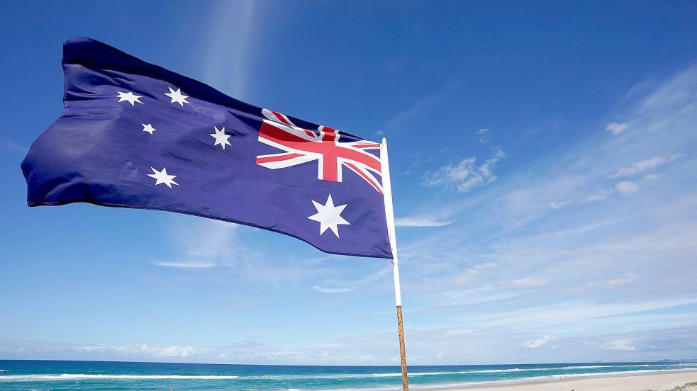 Die australische Flagge an einem Strand (Symbolbild). Foto: Dave Hunt/AAP/dpa