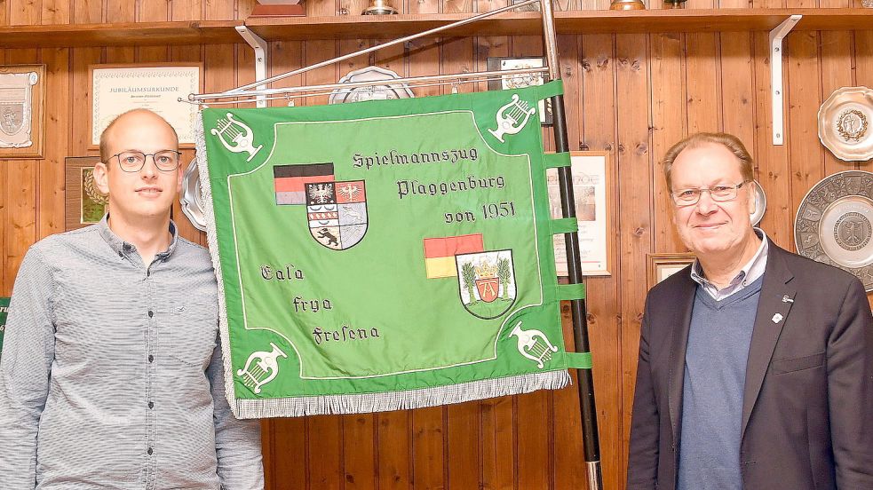Andre Janssen (links), Vorsitzender des der Spielmanns- und Fanfarenzugs Plaggenburg, zusammen mit seinem Vorgänger Artur Mannott, zwischen ihnen die Standarte des Vereins. Beide bedauern das wahrscheinlich baldige Aus des Vereins. Foto: Gerd-Arnold Ubben