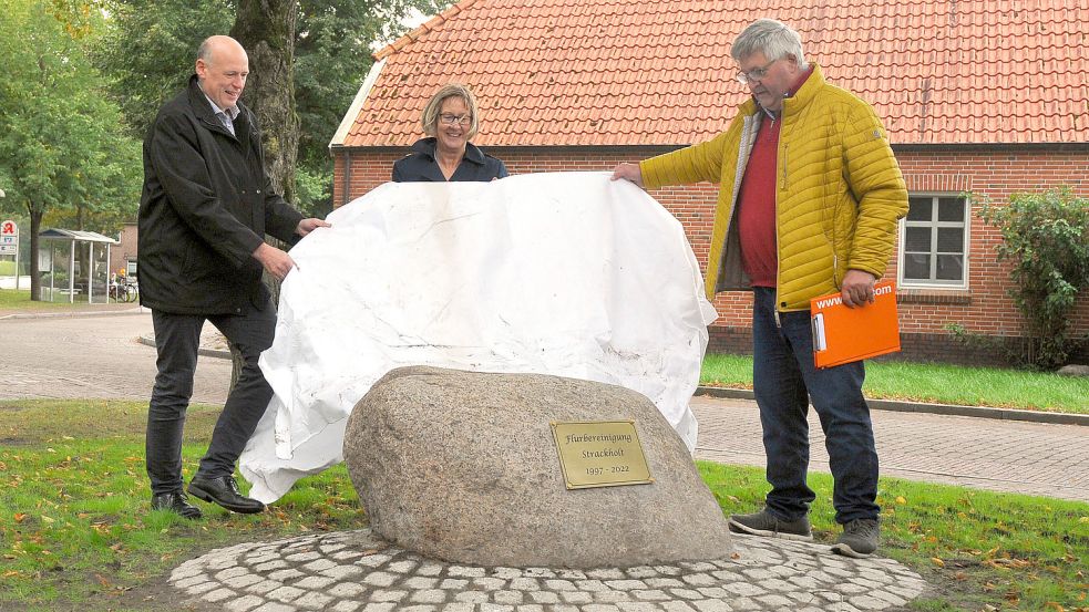 Bürgermeister Erwin Adams (von links), Marlies Wieghaus vom Amt für regionale Landesentwicklung sowie Johann Meyer, Vorsitzender des Vorstandes der Flurbereinigung, bei der Enthüllung des Gedenksteins. Foto: privat