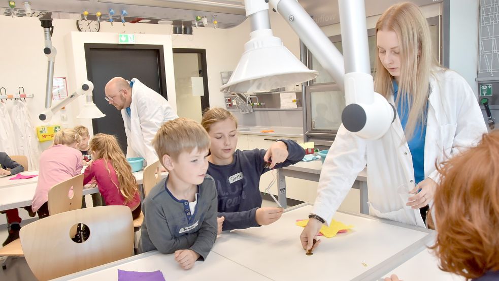 Spannendes Experiment: Wie ein Elektromagnet funktioniert, erklären hier die EEZ-Mitarbeiter Annika Jacobs und Olaf Sievers (im Hintergrund) den Kindern. Foto: Thomas Dirks