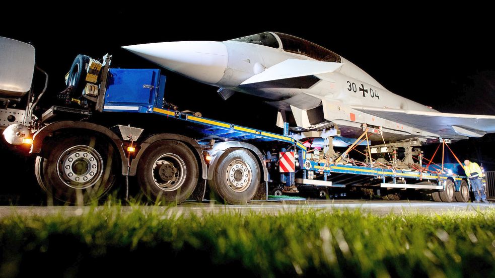 Der Schwertransport stand am Donnerstagabend mit einem Kampfflugzeug vom Typ Eurofighter Typhoon der Luftwaffe vor der Einfahrt zum Fliegerhorst Wittmundhafen. Foto: Hauke-Christian Dittrich/dpa