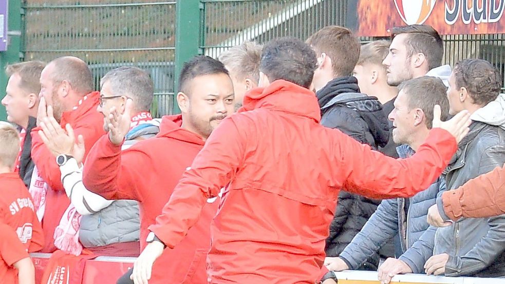 Der Trainer des SV Großefehn Bi Le Tran (links) klatscht den verletzten Kapitän Jannik Swieter beim 4:0-Auswärtssieg in Wallinghausen ab. Foto: Bernd Wolfenberg
