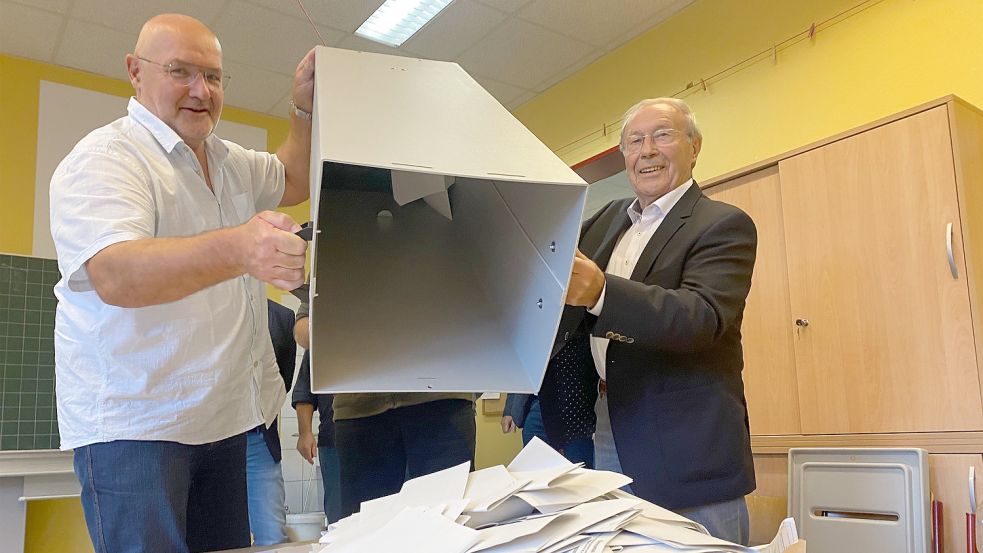 Hartmut Decker (links) und Hinrich Goes lehrten die Wahlurne in der Grundschule Victorbur. Foto: Holger Janssen