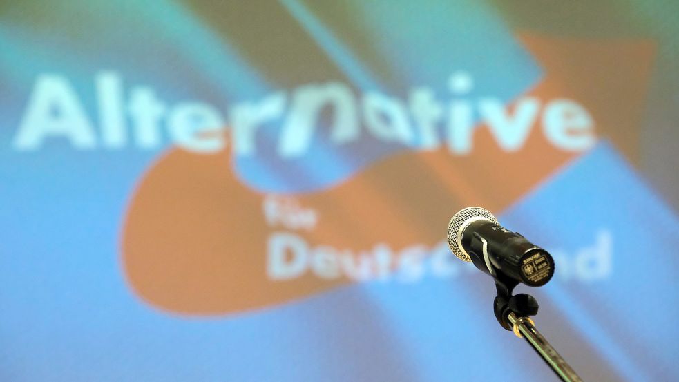 Ein Mikrofon steht bei einem Landesparteitag auf der Bühne vor dem Partei-Logo.Foto: DPA