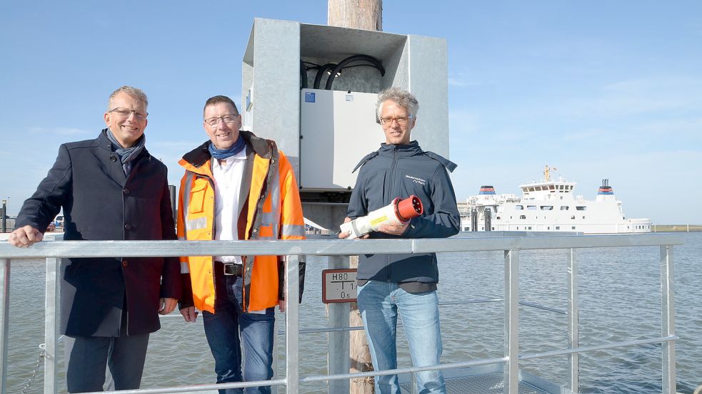 Die neuen Anschlüsse für Hybridschiffe liegen im Osthafen nahe des Anlegers des Töwerland-Express und gegenüber der Fähren der Reederei Frisia. Das Bild zeigt Holger Banik (von links), Friedrich Voß und Markus Sperling. Foto: Hillebrand