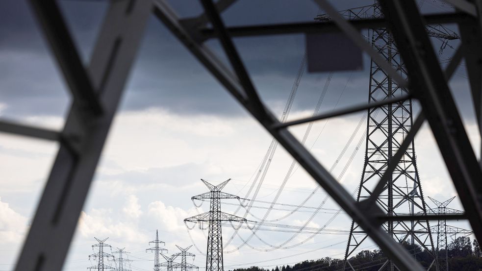 Strommasten einer Höchstspannungsleitung stehen unter dunklen Wolken. Foto: DPA