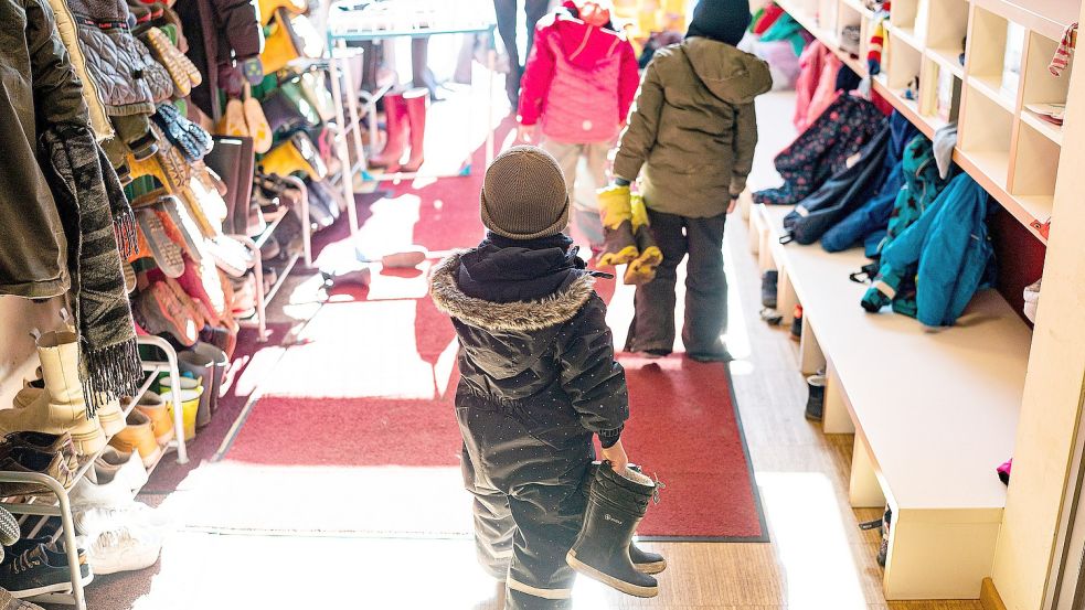 Kinder ziehen sich an, um im Außengelände zu spielen. Foto: DPA