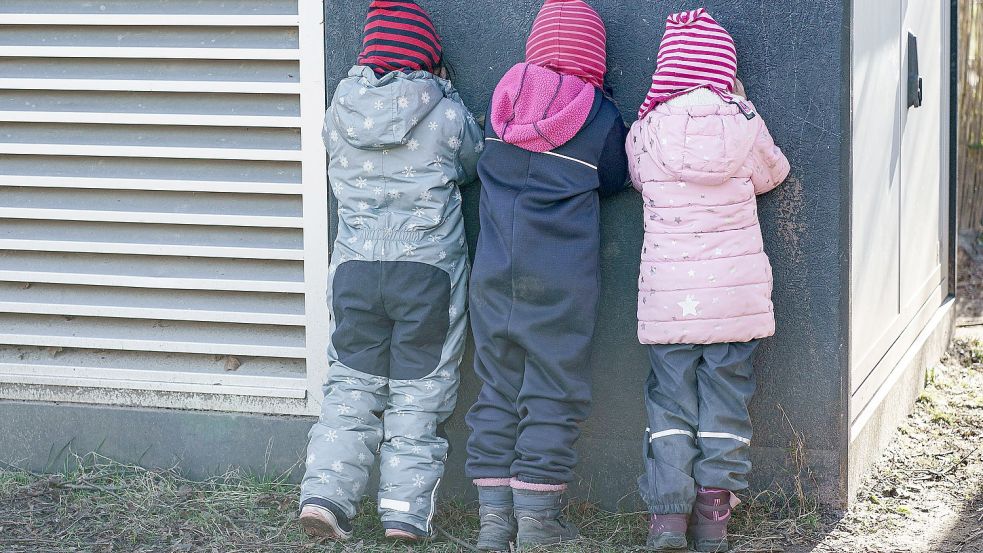 Kinder spielen im Außengelände verstecken. Foto: DPA