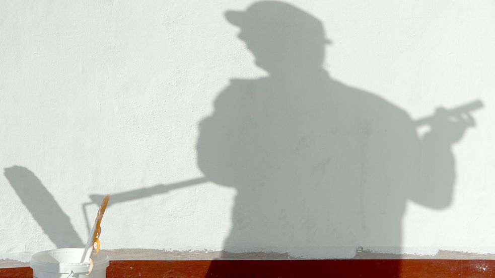 Ein Maler ist auf einer Baustelle beschäftigt und wirft dabei einen langen Schatten. Foto: DPA