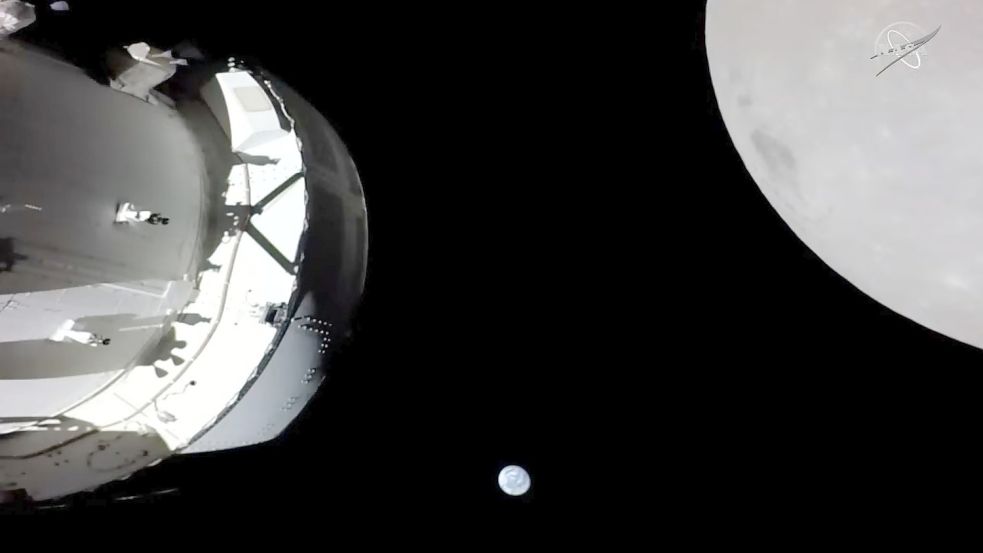 Eine Kamera an Bord der „Orion“-Kapsel zeigt das Raumschiff (l) im Weltraum, den Mond (r) und klein im Hintergrund die Erde. Foto: Nasa TV/dpa