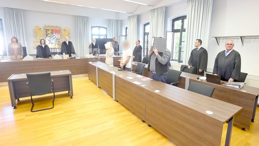 Eine Jugendlicheund ein Erwachsener stehen in einem Gerichtssaal des Landgerichtes vor der Anklagebank.Die beiden sind angeklagt, gemeinsam eine 16-Jährige getötet zu haben. Foto: Karl-Josef Hildenbrand/dpa