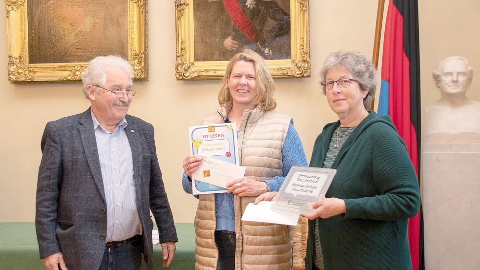 Rico Mecklenburg überreichte Bettina Tammen (Mitte) und Heike Schürmann von der Pfälzerschule die Auszeichnung „Mehrsprachige Grundschule“. Foto: Ostfriesische Landschaft