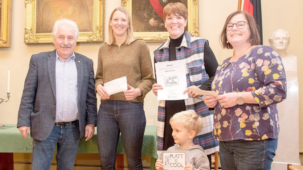 Landschaftspräsident Rico Mecklenburg mit Karola Coordes, Dunja Holzhausen und Silvia Fleßner von der KGS Großefehn mitsamt tatkräftiger Hilfe zum Tragen der Plakette „Platt is cool“. Foto: Ostfriesische Landschaft