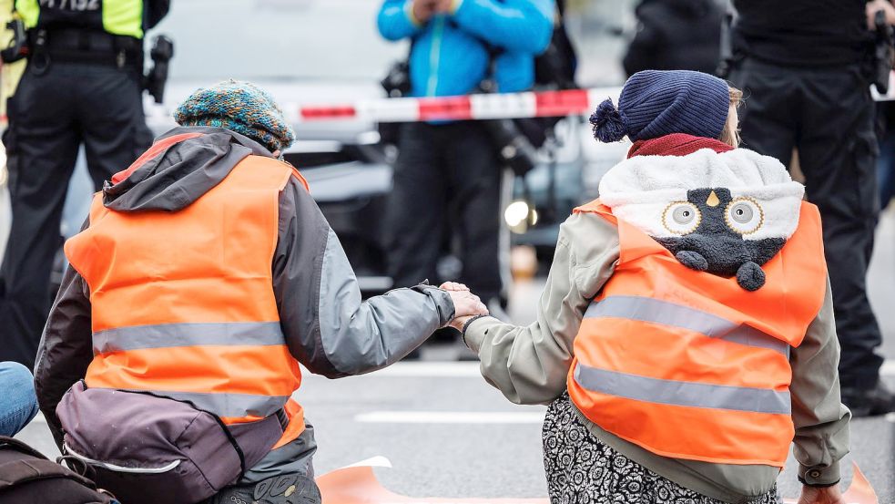 Aktivisten der „Letzten Generation“ haben sich am Stachus auf die Straße geklebt. Foto: Matthias Balk/dpa